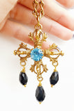 Collana croce con cristallo centrale in azzurro e pendenti in nero