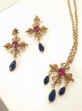 Set collana e orecchini con croce con cristallo centrale in fucsia e pendenti in nero